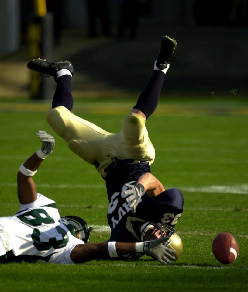 US Navy 031101-N-9693M-474 Tulane wide receiver Carl Davis stretches for a tipped pass as Navy safety Josh Smith rolls out of the play during Navy's 35-17 victory over Tulane