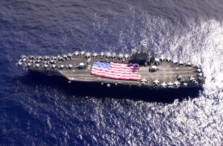 US Navy 031103-N-6536T-002 USS Nimitz (CVN 68) crewmembers participate in a flag unfurling rehearsal with the help of family and friends on the ship's flight deck