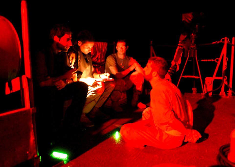 US Navy 030929-C-3550N-004 A member of U.S. Coast Guard Law Enforcement Detachment 407 (USCG LEDET 407) stands watch over four suspected sea-faring bandits