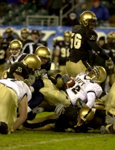 US Navy 031206-N-9693M-522 Navy fullback Bronston Carroll is tackled by a group of Army defenders during the 104th Army Navy Game photo