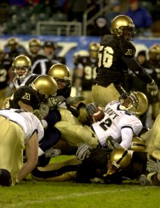 US Navy 031206-N-9693M-522 Navy fullback Bronston Carroll is tackled by a group of Army defenders during the 104th Army Navy Game