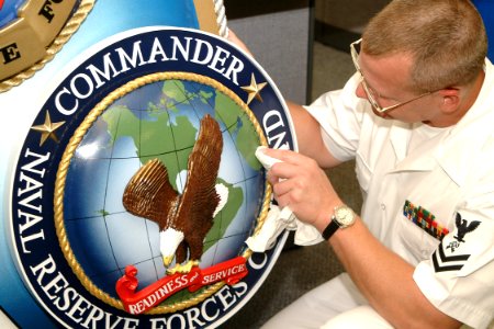 US Navy 030930-N-7542D-002 Storekeeper Second Class Frederick S. Short of Naval Cargo Handling Battalion Ten, Williamsburg, Va., puts the finishing touches on a three-dimensional tri-staff emblem