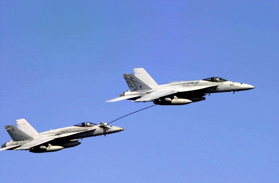 US Navy 031101-N-2385R-016 Two F-A-18 Hornets perform re-fueling maneuvers while passing USS Nimitz (CVN 68) as part of an air show demonstration during a Tiger Cruise aboard the ship