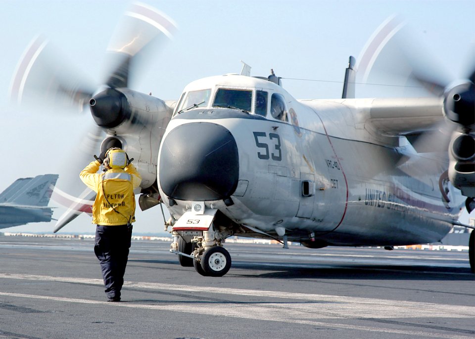 US Navy 031118-N-6278K-003 Aviation Boatswain's Mate 3rd Class Jesse Borja directs a C-2A Greyhound