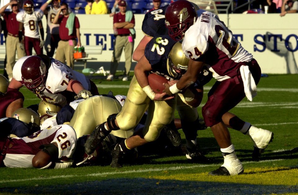 US Navy 031122-N-9693M-012 Navy fullback Kyle Eckel bounds past Central Michigan's James King for a touchdown during the Midshipmen's win over the Chippewas 63-34 in Annpolis, Md