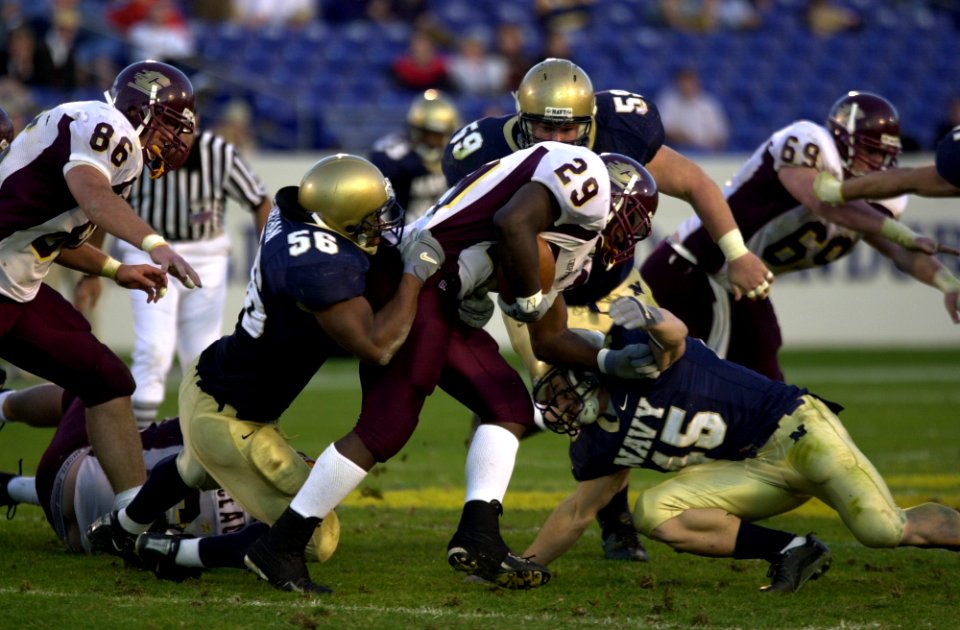 US Navy 031122-N-9693M-023 Navy defenders Eddie Carthan (56), Kevin Schwind (59) and Eli Sanders (45), tackle Central Michigan's Terrance Jackson during the Midshipmen's win over the Chippewas 63-34 in Annpolis, Md