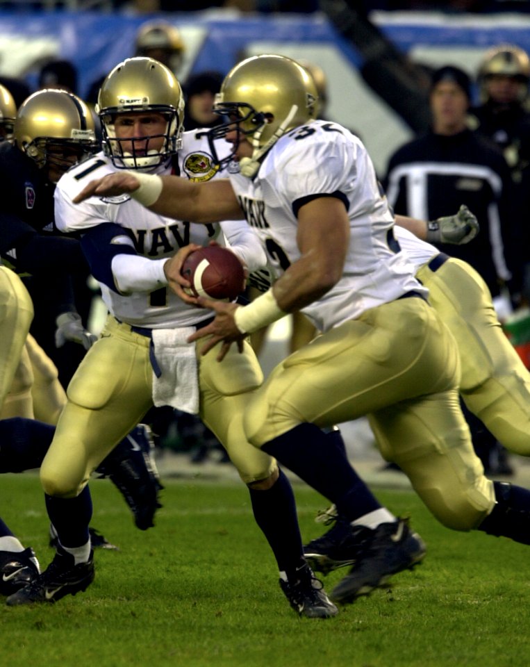 US Navy 031206-N-9693M-028 Navy quarterback Craig Candeto hands off to fullback Kyle Eckel during the 104th playing of the Army Navy game at Lincoln Financial Field, Philadelphia, Pa