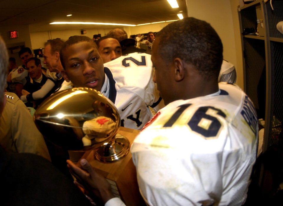 US Navy 031206-N-9693M-024 Navy defensive back Shalimar Brazier holds the Secretary's Trophy with fellow defensive back Vaughn Kelly following the 104th playing of the Army Navy game