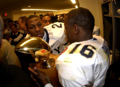 US Navy 031206-N-9693M-024 Navy defensive back Shalimar Brazier holds the Secretary's Trophy with fellow defensive back Vaughn Kelly following the 104th playing of the Army Navy game photo