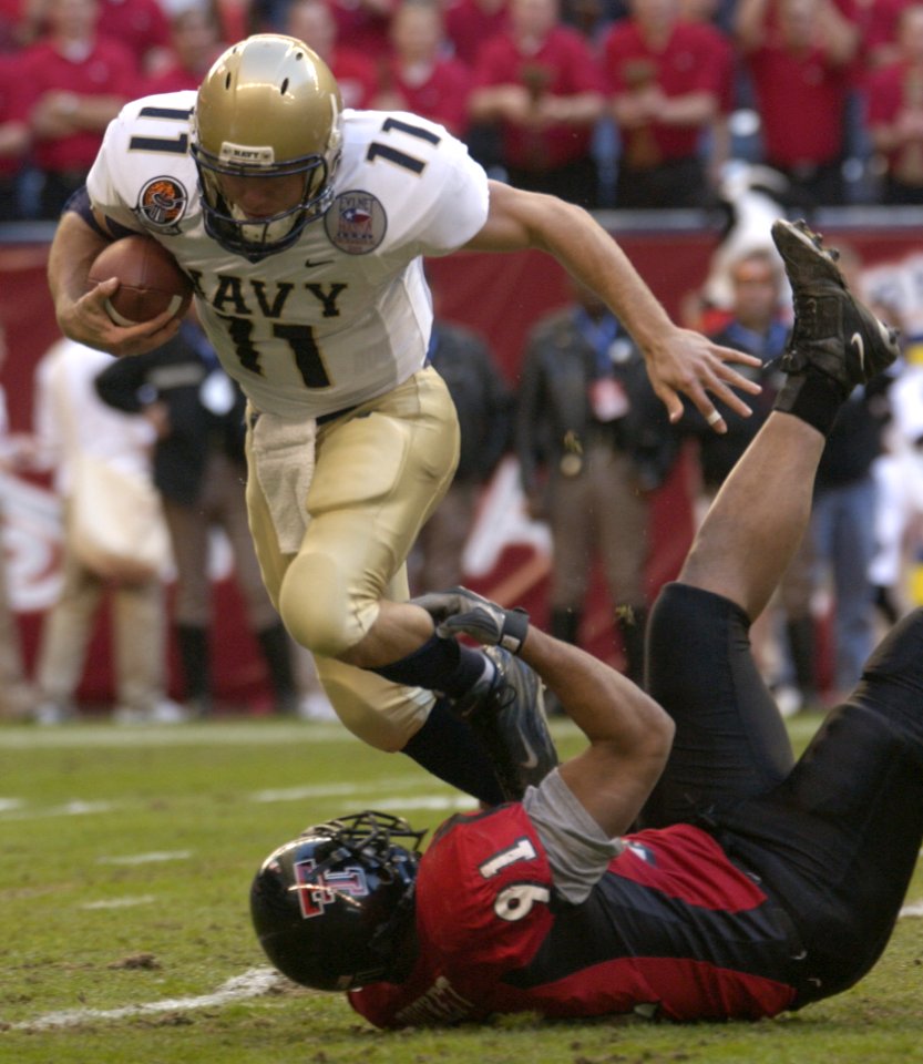 US Navy 031230-N-9693M-005 Navy quarterback Craig Candeto is tackled by Texas Tech nose guard Adell Duckett in the EV1.Net Houston Bowl at Reliant Stadium in Houston, Texas