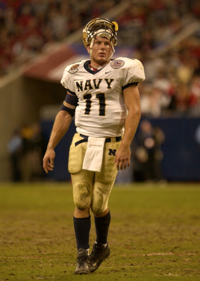 US Navy 031230-N-9693M-021 Navy quarterback Craig Candeto recovers from a tough rushing attempt which ended in a tackle that jarred his helmet loose in the EV1.Net Houston Bowl at Reliant Stadium in Houston, Texas