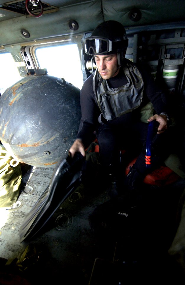 US Navy 031213-N-5319A-008 Gunner's Mate 1st Class Casey Rodgers, assigned to Explosive Ordnance Disposal Mobile Unit Six (EODMU-6) prepares his dive gear before deploying from a SH-60 Seahawk