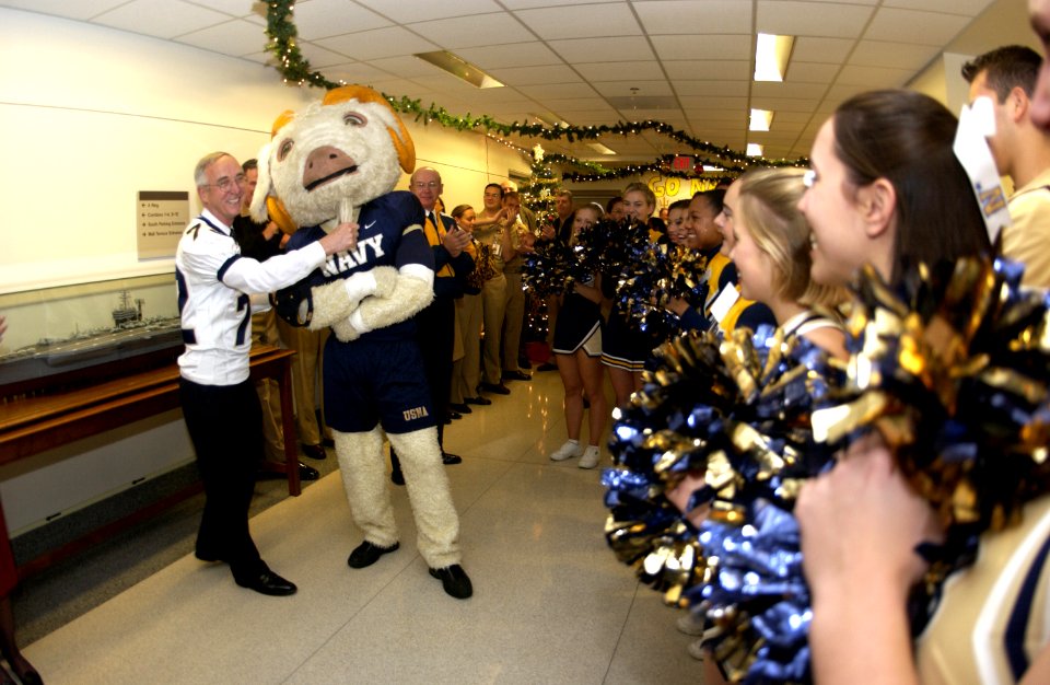 US Navy 031204-N-9693M-033 The Secretary of the Navy, the Honorable Gordon R. England tugs on Bill the U.S. Naval Academy mascot, as Midshipmen cheerleaders and band members conduct a Go Navy, Beat Army pep rally