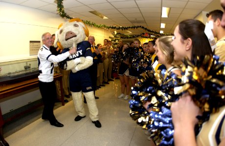 US Navy 031204-N-9693M-033 The Secretary of the Navy, the Honorable Gordon R. England tugs on Bill the U.S. Naval Academy mascot, as Midshipmen cheerleaders and band members conduct a Go Navy, Beat Army pep rally
