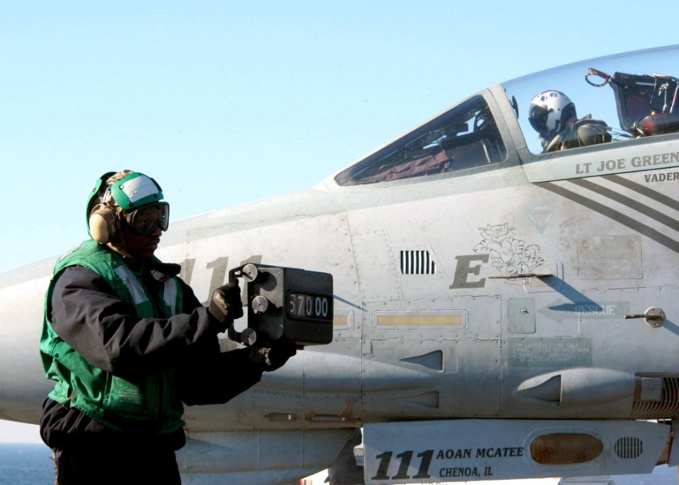 US Navy 040122-N-6278K-001 Airman Joshua Sumpter from Effingham, S.C., shows the weight board to the catapult operator as an F-14B Tomcat assigned to the Pukin' Dogs of Fighter Squadron One Four Three (VF-143) prepares to launch