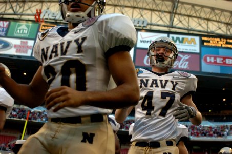 US Navy 031230-N-2653P-133 Navy safeties Paul Clarkson and Clay Carter charge on the field prior to the Naval Academy's game with Texas Tech in the EV1.Net Houston Bowl
