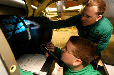 US Navy 040127-N-6278K-002 Photographer's Mate 1st Class Brian Goyak, from Smethpoet, Pa., and Photographer's Mate 1st Class Daniel Wolsey, from Springville, Utah, assigned to Pukin' Dogs of Fighter Squadron One Four Three (VF-143)