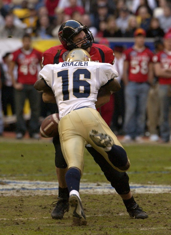 US Navy 031230-N-9693M-009 Navy cornerback Shalimar Brazier sacks Texas Tech quarterback B.J. Symons in the 2nd quarter of the EV1.Net Houston Bowl at Reliant Stadium in Houston, Texas