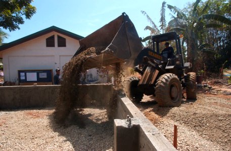 US Navy 040219-N-4142G-002 A front loader assigned to the Club and Spades of Naval Mobile Construction Battalion Two Five (NMCB 25), pours earth to be used in the building of a foundation at the Manuel Memorial El
