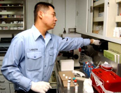 US Navy 040116-N-0000W-113 Hospital Corpsman 3rd Class Salvador Labuzon works in a medical department space photo