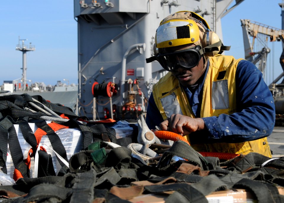 US Navy 110204-N-OY473-100 Boatswain's Mate Seaman David Lisma unloads supplies during an underway replenishment aboard USS Carter Hall (LSD 50)