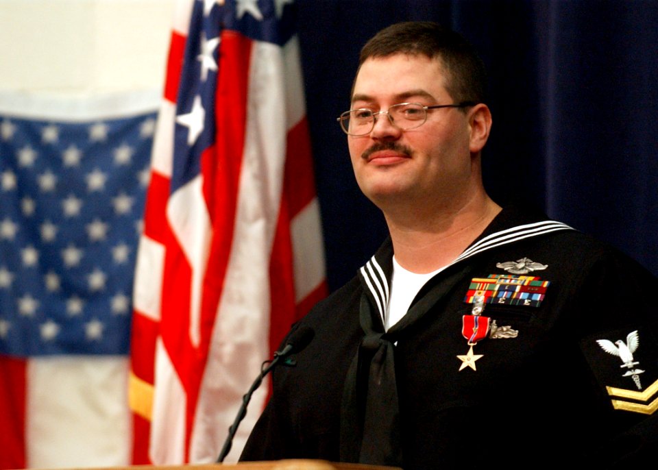 US Navy 040223-N-5576W-003 Hospital Corpsman 2nd Class Alan Dementer of Gladstone, Mich., addresses an audience of friends, family and co-workers, following the awarding of the Bronze Star