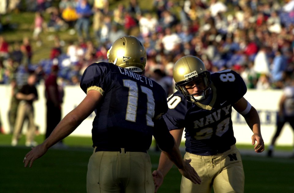 US Navy 031122-N-9693M-022 Navy kicker Eric Rolfs, right, and quarterback Craig Condeto congratulate each other following a point after touchdown during the Midshipmen's win over the Chippewas 63-34 in Annpolis, Md