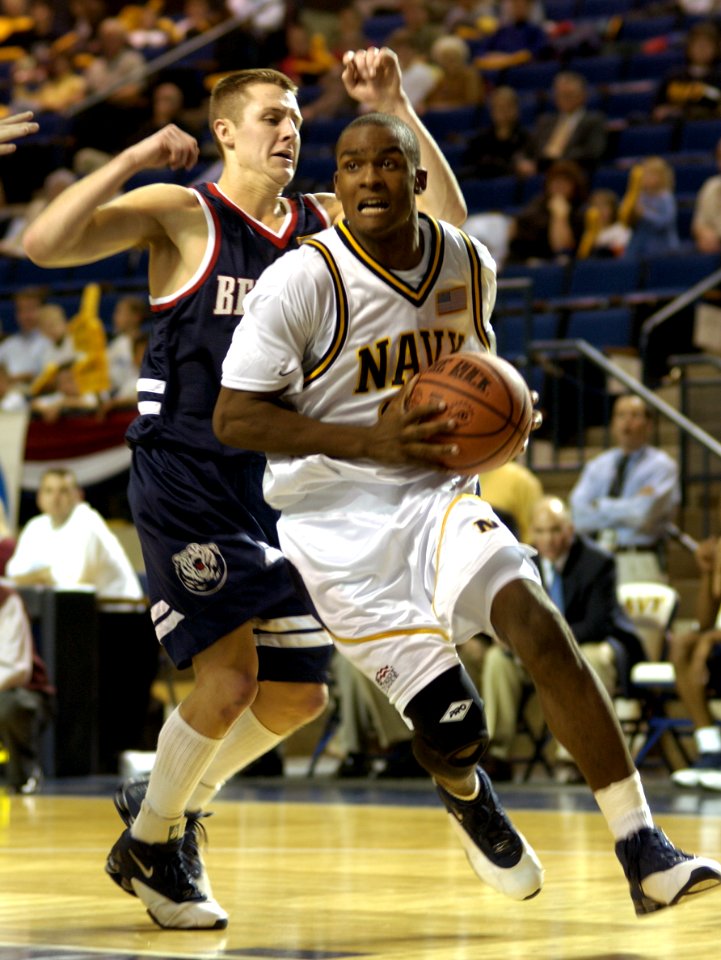 US Navy 031124-N-9693M-002 Navy junior guard Taj Matthews rounds Belmont senior guard Steve Drabyn during the Midshipmen's home opener at the U.S. Naval Academy