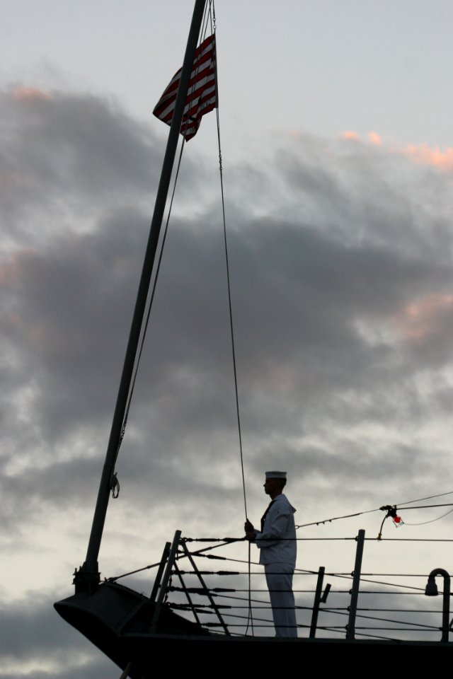US Navy 031219-N-3228G-008 A watch stander conducts evening colors aboard the newly-commissioned guided missile destroyer USS Chafee (DDG 90) on the first day in her new homeport, Pearl Harbor, Hawaii
