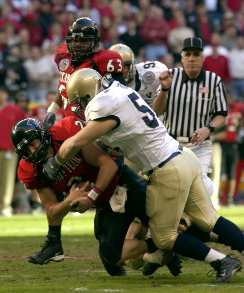 US Navy 031230-N-9693M-004 Navy linebacker Bobby McClarin sacks Texas Tech quarterback B.J. Symons during the EV1.Net Houston Bowl at Reliant Stadium in Houston, Texas