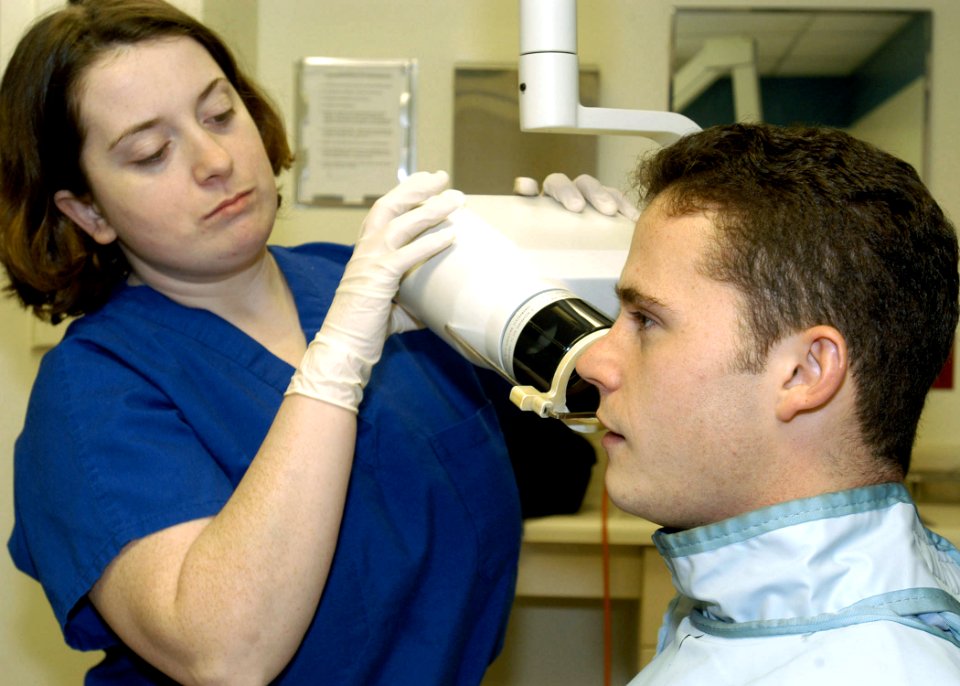 US Navy 040127-N-5134H-001 Using an Intraoral Radiography machine, Dental Technician Ramona Loporto, X-ray's Photographer's Mate 2nd Class Michael Watkins, teeth and gum lines during a routine dental examination