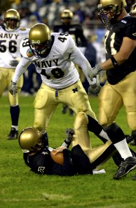 US Navy 031206-N-9693M-031 Navy linebacker Jeremy Chase stands over Army quarterback Zac Dahman after a sack during the 104th playing of the Army Navy game photo