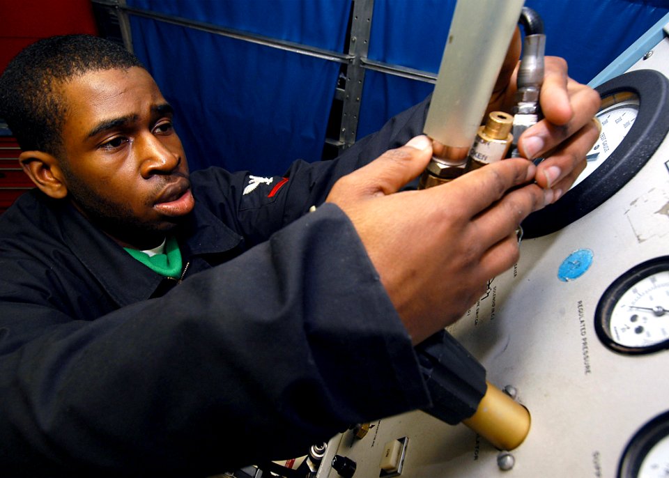 US Navy 040204-N-6278K-002 Aviation Boatswain's Mate 3rd Class Brandon Billups, from Newark, N.J., calibrates a tire gauge for an F-14 Tomcat and an F-A-18 Hornet aircraft on a tire gauge calibration bench