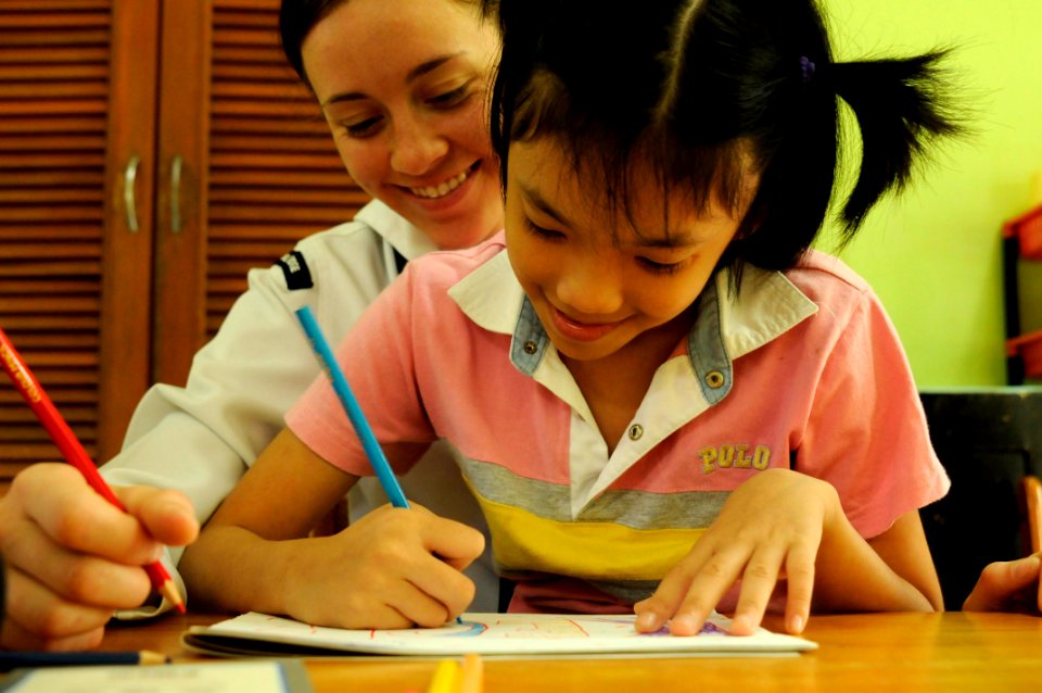 US Navy 110302-N-9094S-060 Ship's Serviceman Seaman Krista Stelzner draws pictures with a child during a community service event