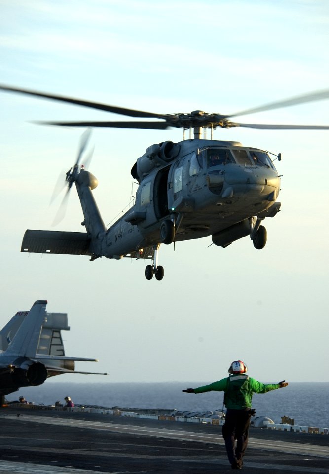 US Navy 040218-N-5319A-005 Aviation Machinist's Mate 3rd Class Derrick Chapman, assigned to the Nightdippers of Helicopter Anti-Submarine Squadron Five (HS-5), directs a HH-60H Seahawk