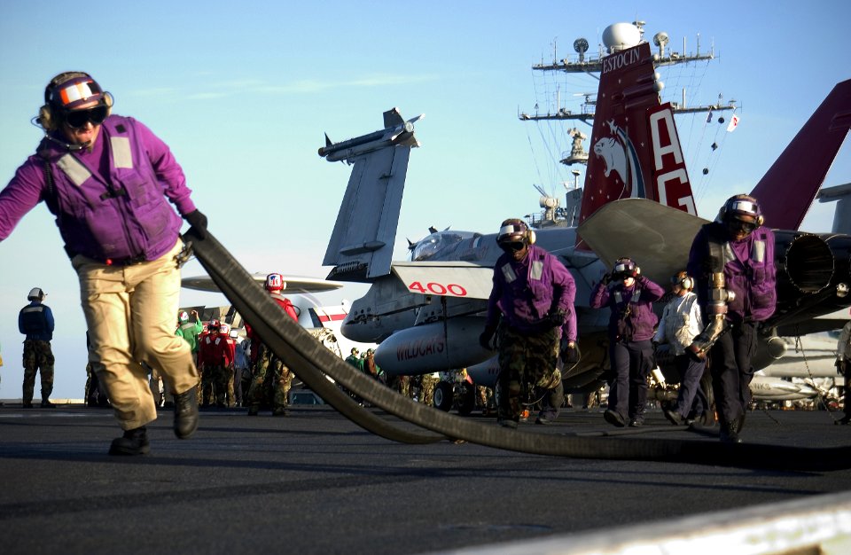 US Navy 040218-N-5319A-001 Chief Aviation Boatswain's Mate Fuel, Eduardo Docarmo, and his crew from the ship's V-4 fuel division, remove fuel hose