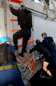US Navy 040224-N-4374S-005 A member of the Vessel, Board, Search, and Seizure (VBSS) team assigned to the guided missile destroyer USS Roosevelt (DDG 80) climbs down a pilot's ladder to a Rigid Hull Inflatable Boat (RHIB)