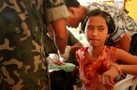 US Navy 040226-N-4142G-023 A young child receives medical aid from military personnel participating in the Medical Civic Action Program (MEDCAP) in Bargangay San Miguel as a part Exercise Balikatan 2004