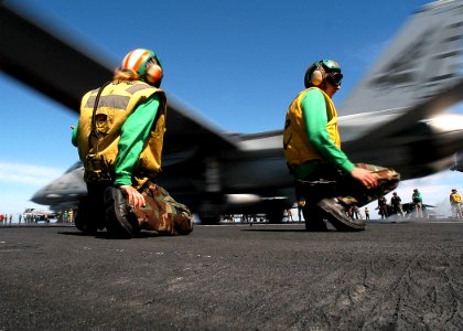 US Navy 040217-N-3986D-020 Flight deck catapult crew members work the ship's flight deck as an F-14B Tomcat s launched from the flight deck