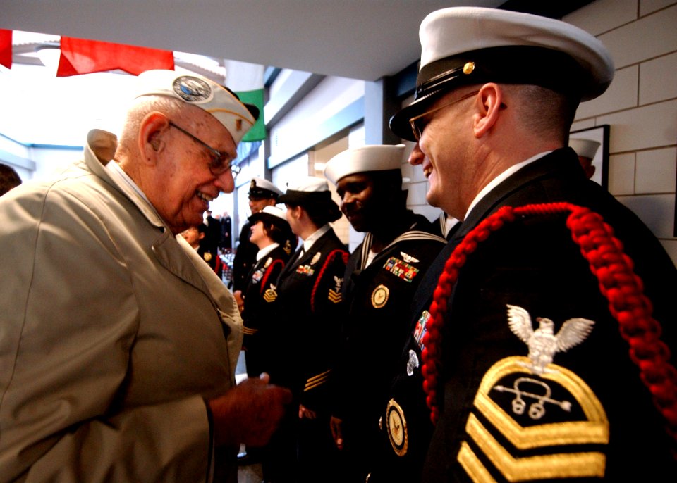 US Navy 040224-N-5576W-001 Pearl Harbor veteran Francis Gringas of Gurnee, Ill., talks with a Recruit Division Commander (RDC) following the commissioning of the USS Arizona Recruit Barracks