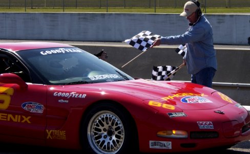 US Navy 040321-N-5862D-206 Cmdr. Brad Neff takes the checkered flag for a victory lap at the Memphis Motor Speedway in the Sports Car Club of America's (SCCA) first national race photo