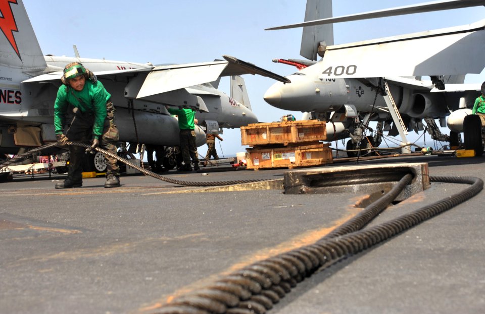 US Navy 110513-N-0569K-025 Aviation Boatswain's Mate (Equipment) 3rd Class Richsan B. Magpantay reweaves the three wire on the flight deck of the a