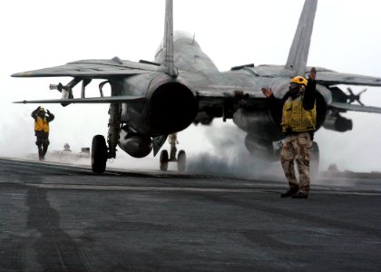 US Navy 040108-N-7090S-003 Flight deck personal direct an F-14 Tomcat assigned to the Checkmates of Fighter Squadron Two One One (VF-211)
