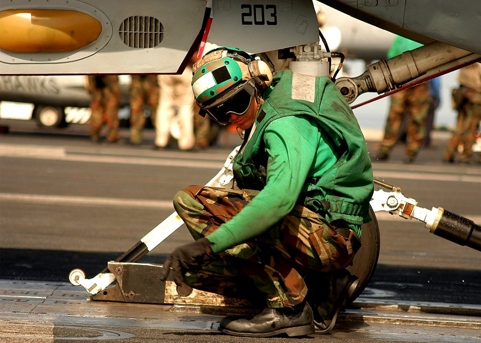 US Navy 040224-N-3986D-027 Aviation Boatswain's Mate Airman Alfred Noce directs the final aircraft positioning of an F-14B Tomcat