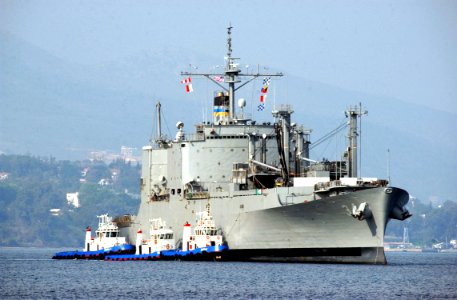 US Navy 040317-N-0780F-015 USNS Mount Baker (T-AE 34) is assisted by tugs as she arrives for a routine port visit at Souda Bay, Crete, Greece photo