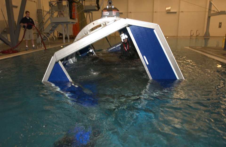 US Navy 040225-N-6436W-003 Instructors assigned to Naval Air Station (NAS) Whidbey Island's Aviation Survival Training Center prepare to demonstrate the Navy's new Modular Egress Training System