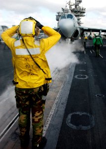 US Navy 040226-N-4374S-003 An aircraft director signals to an EA-6B Prowler assigned to the Scorpions of Electronic Attack Squadron One Three Two (VAQ-132) to taxi forward on catapult number one