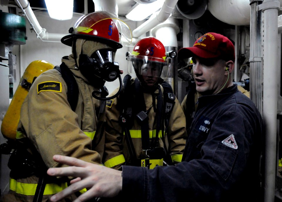 US Navy 110614-N-KB052-117 Machinery Repairman 1st Class Jason Rink talks with junior Sailors about the techniques and challenges of shipboard fire