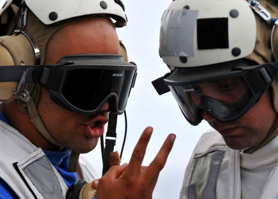 US Navy 110625-N-PB383-500 Operations Specialist 3rd Class Brandon Lamm relays information to Boatswain's Mate 2nd Class Mark Fears during deck lan