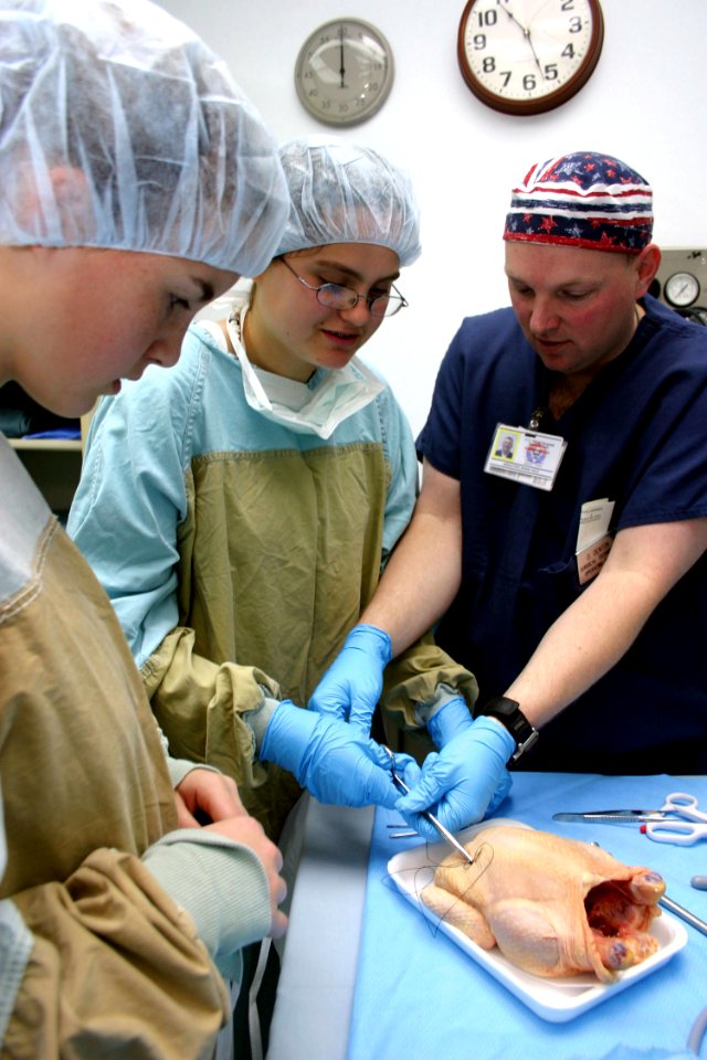 US Navy 040331-N-5821W-005 Hospital Corpsman 2nd Class Damon Denton shows eighth-grade students from Naval Air Station Sigonella's Stephen Decatur School how to perform a suture using a chicken